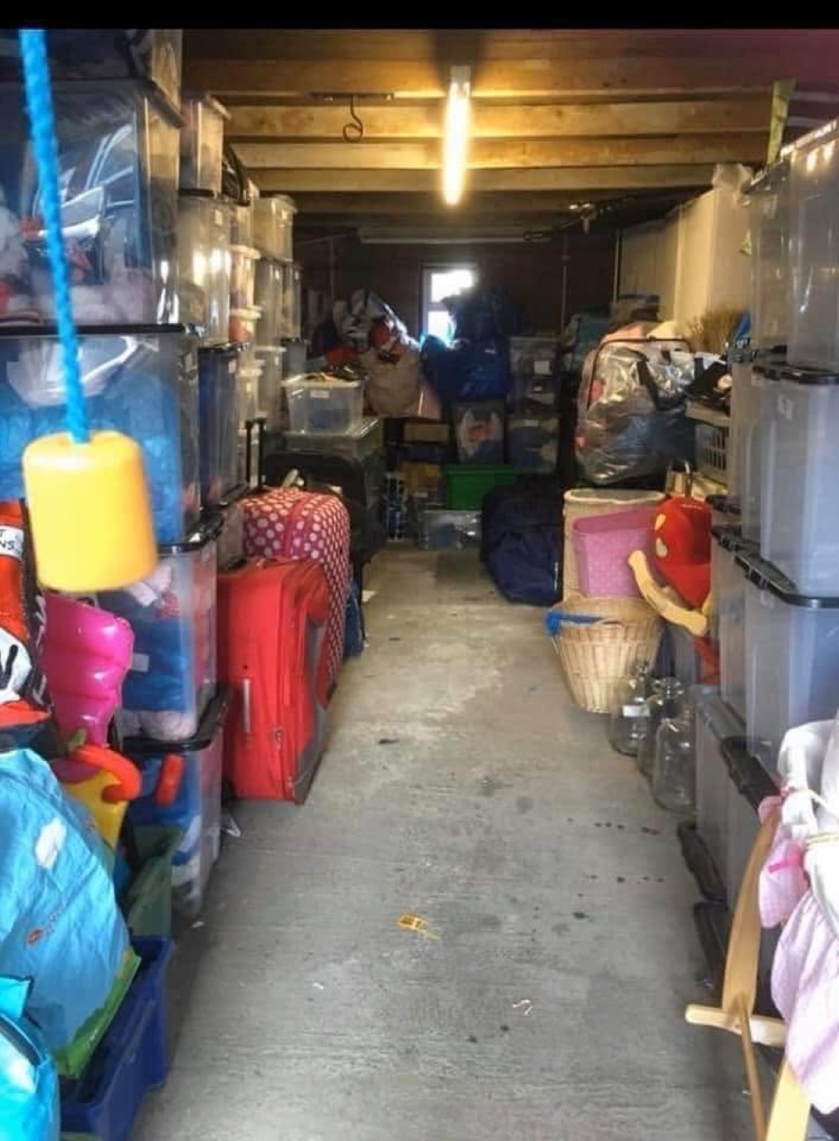 Storage boxes and bags of donations packed inside the Angels Treasure Cove garage